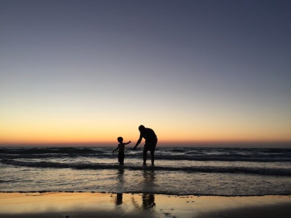 海岸での男と子供のシルエット