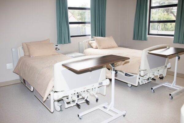 窓際の白い病院用ベッド
