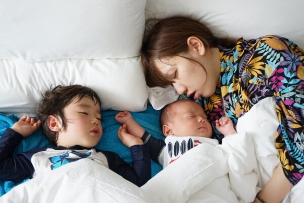 お母さん、赤ちゃん、男の子が昼寝をしている