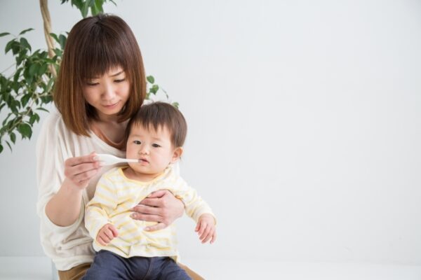 赤ちゃんの熱を測る女性