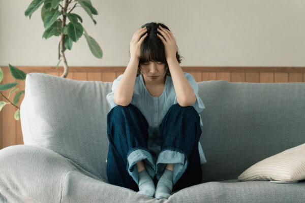 頭を抱えて悩む女性
