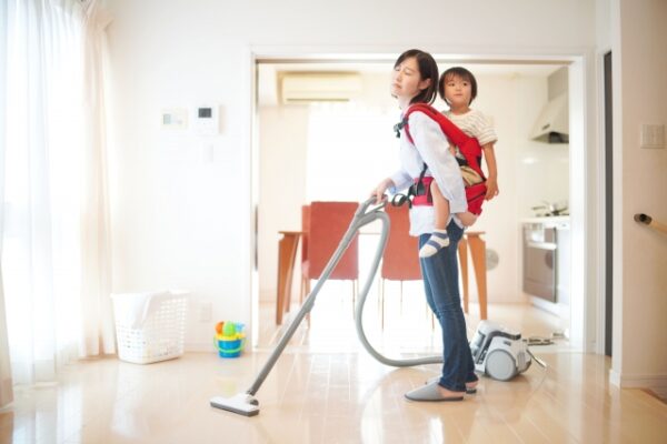 子供をおんぶして掃除をするお母さん